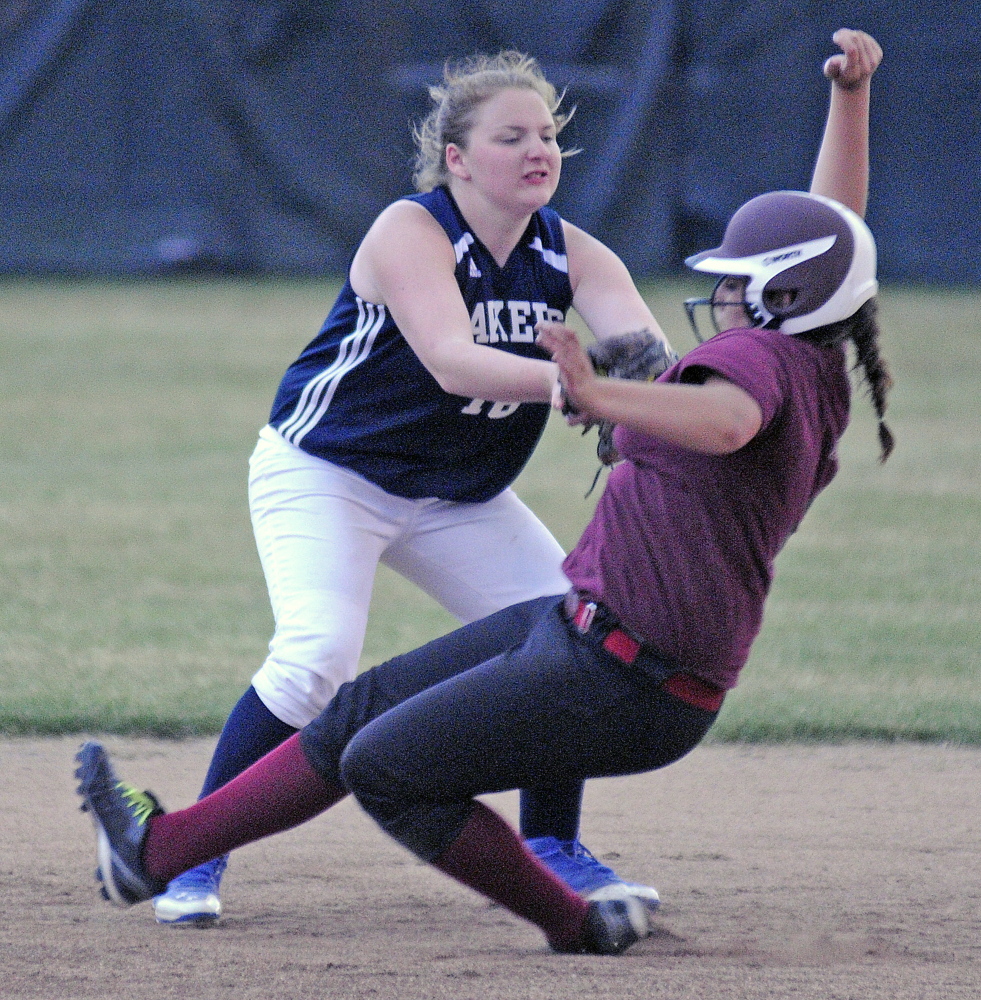 Richmond High School’s Emily Douin gets snagged by Greenville High School’s Danielle Mills during the Western D softball final on Wednesday June 18, 2014 in Standish.