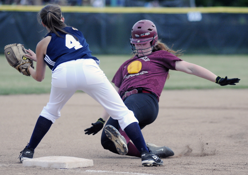 Richmond High School’s Kalah Patterson slides under the tag of Greenville High School’s Grace Bilodeau during the Western D softball final on Wednesday June 18, 2014 in Standish.