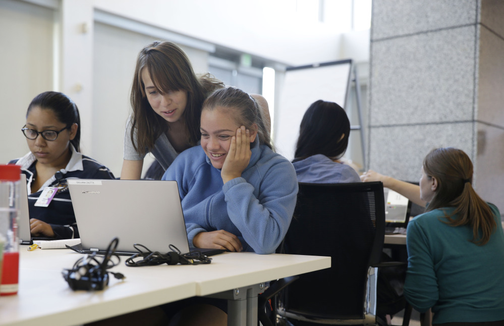 Teacher assistant Margarita Sokolova, second from left, helps Giuliana Zautta, 17, of Menlo Park, Calif., during a Girls Who Code class at Adobe Systems in San Jose, Calif. The summer program will reach 380 high school girls across 19 classes in New York, Boston, Miami, Seattle and the Bay Area.