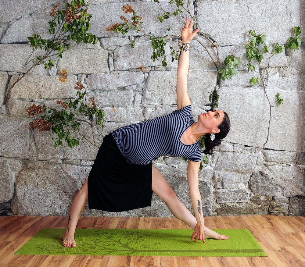 Suzanne Imbruno Cobb, who says yoga helped ease her Lyme disease, demonstrates a triangle pose at Panacea Yoga Studios at 101 Second St. in Hallowell.