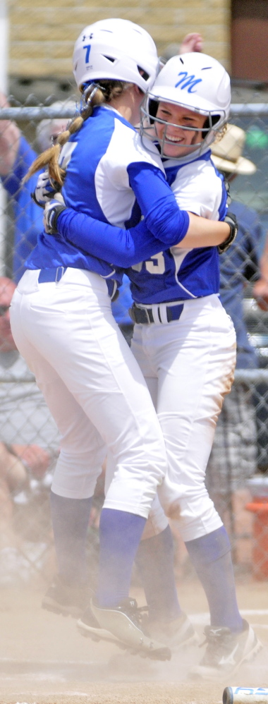 Madison’s Kirstin Wood hugs teammate Madeline Wood after crossing home plate to score the Bulldog’s only run during the class C softball state championship on Saturday in Standish. The Bulldogs beat Calais 1-0 for the title.