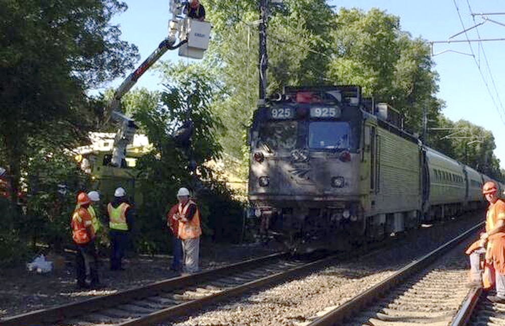Officials work at the scene Monday where an Amtrak train struck a vehicle overnight in Mansfield, Mass. Three people in the vehicle were killed. Service on Amtrak and MBTA lines was delayed.