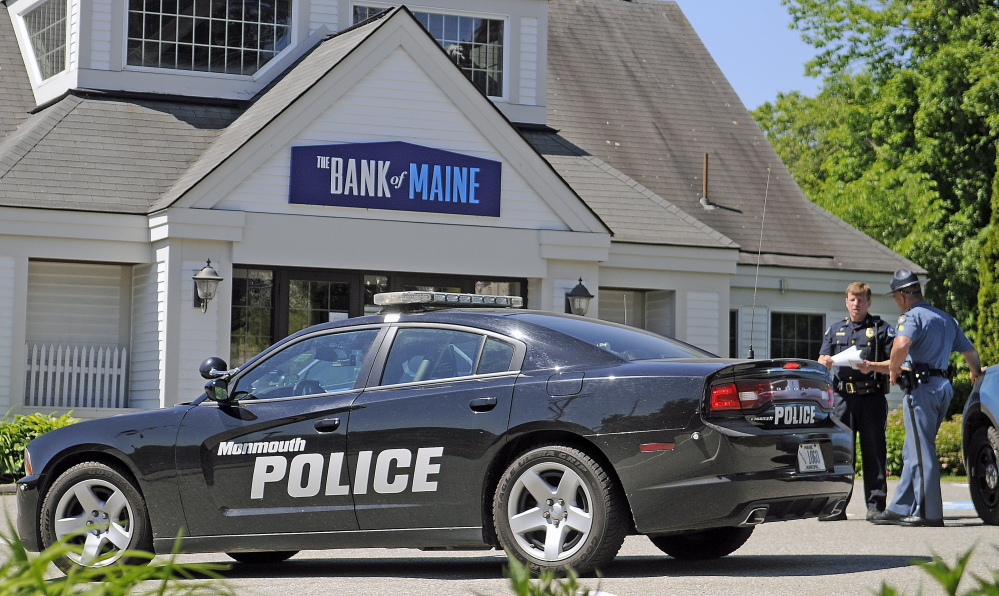 Robbery: Police confer Monday outside of the Bank of Maine branch in Hallowell, where a man reportedly in his 70s robbed the bank and threatened to use a grenade.