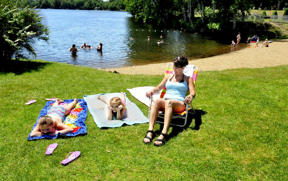 Madison and Izzy Drake and Tracy Liberty relax at the Oakland beach and boat launch on Messalonskee Lake Monday, with no Canada geese in sight. The town had the geese removed by the USDA.