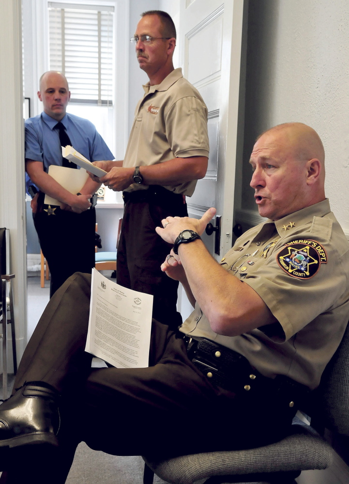 Franklin County Sheriff Scott Nichols, seated, explains how the department will come up with an additional $100,000 for the state Board of Corrections during a meeting with county commissioners in Farmington Tuesday. Waiting to speak at left is Chief Deputy Steve Lowell, left, and jail administrator Doug Blauvelt.
