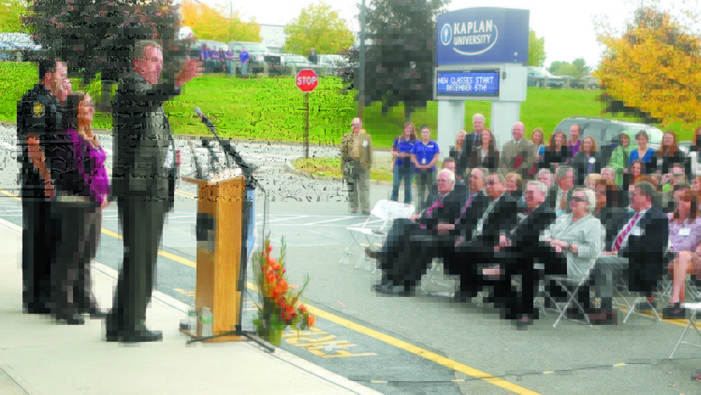 Kaplan University students Augusta Police Officer Matthew Estes, left, and his wife, Jennifer Estes, are introduced by Christopher Quinn, president of Kaplan University Maine, during an opening ceremony for the company’s new Augusta center in October 2012.