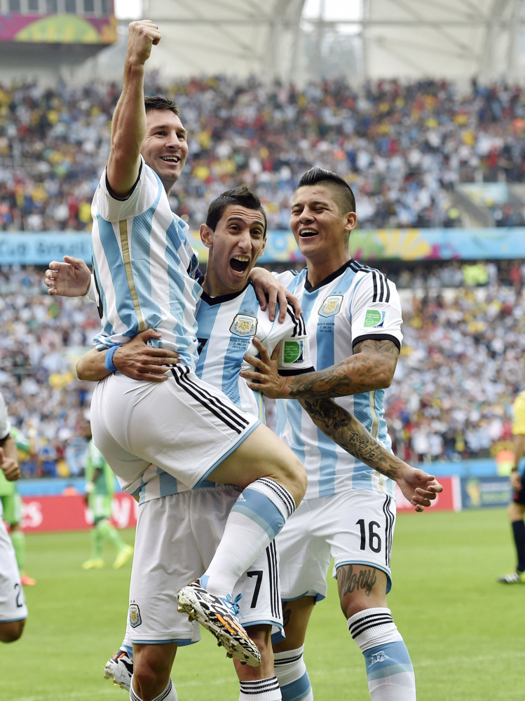 Argentina's Lionel Messi, left, is carried by his teammates Argentina's Angel di Maria (7) and Marcos Rojo (16) after scoring his side's first goal during the group F World Cup soccer match against Nigeria at the Estadio Beira-Rio in Porto Alegre, Brazil, Wednesday, June 25, 2014. (AP Photo/Martin Meissner)