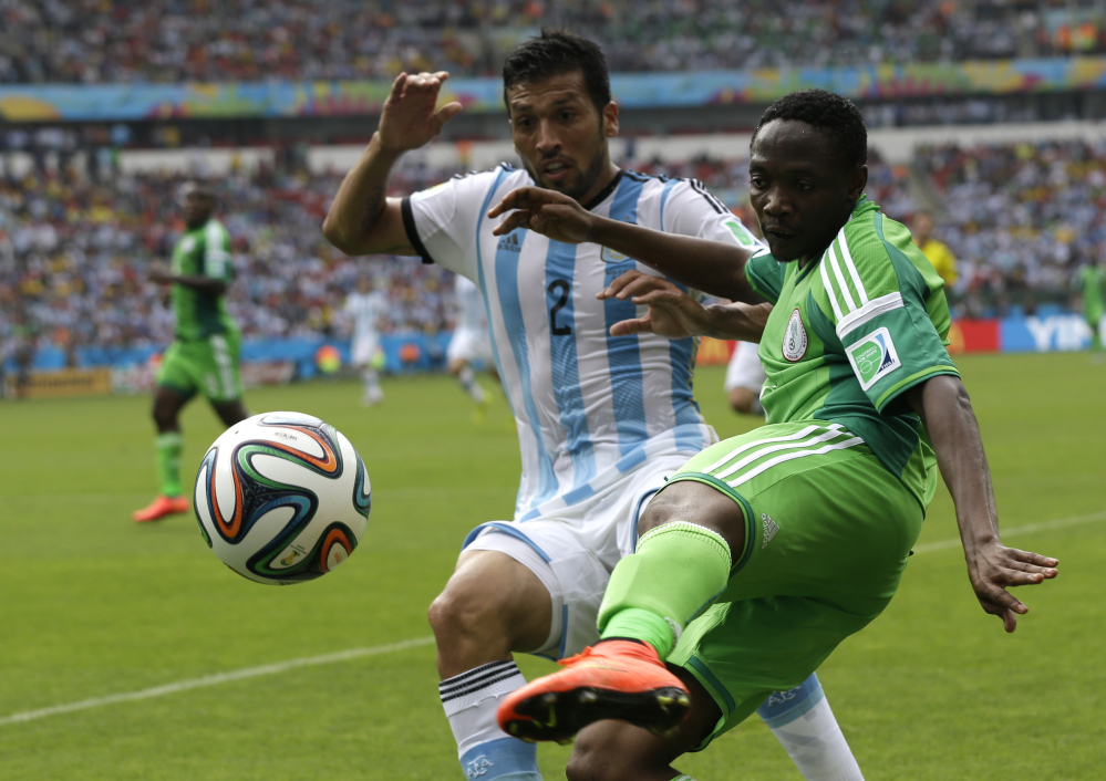 Nigeria's Ahmed Musa, right, and Argentina's Ezequiel Garay challenge for the ball during the group F World Cup soccer match between Nigeria and Argentina at the Estadio Beira-Rio in Porto Alegre, Brazil, Wednesday, June 25, 2014. (AP Photo/Fernando Vergara)