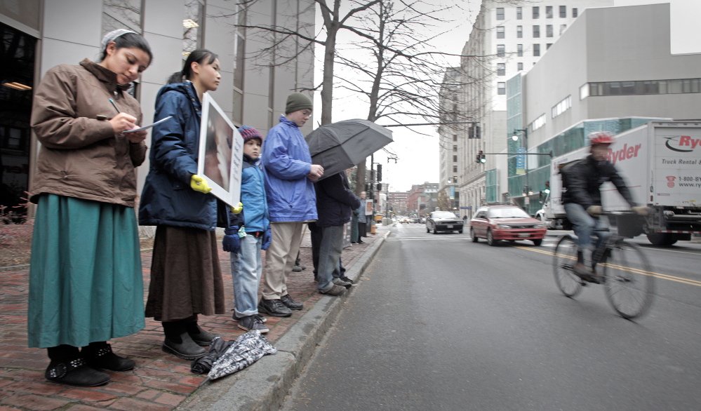 Anti-abortion protesters stand across the street from the Planned Parenthood clinic in Portland on Nov. 22, 2013, the first day they picketed the Congress Street clinic since a 39-foot buffer zone around the clinic took effect.