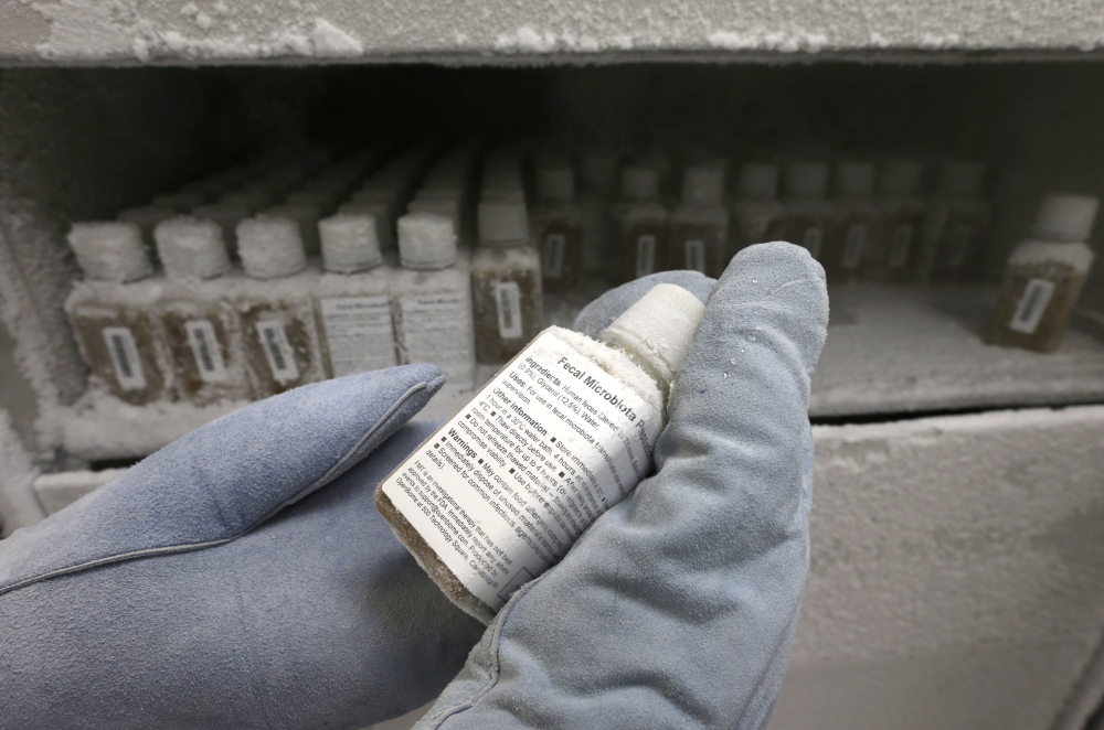 The Associated Press
Technical assistant Eliska Didyk, wearing protective gloves, displays a bottle containing human fecal matter solution, frozen to minus 80 degrees celsius, in an OpenBiome laboratory in Medford, Mass. With many patients no longer responding to potent antibiotics, stool has emerged as a surprisingly effective treatment for hard-to-treat gut infections.
