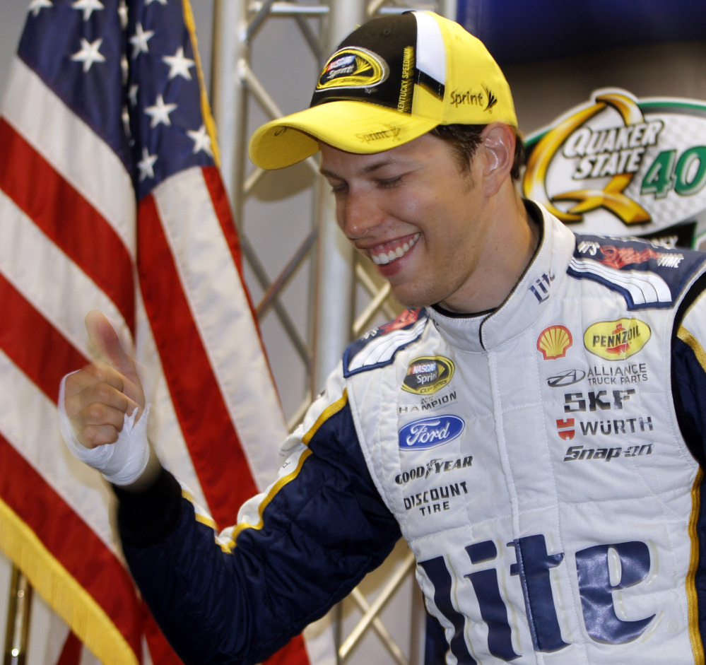 Brad Keselowski gives a thumbs-up with his bandaged hand after the news conference following his victory in the NASCAR Sprint Cup race Saturday night at Kentucky Speedway in Sparta, Ky. Keselowski injured his hand on a broken champagne bottle.