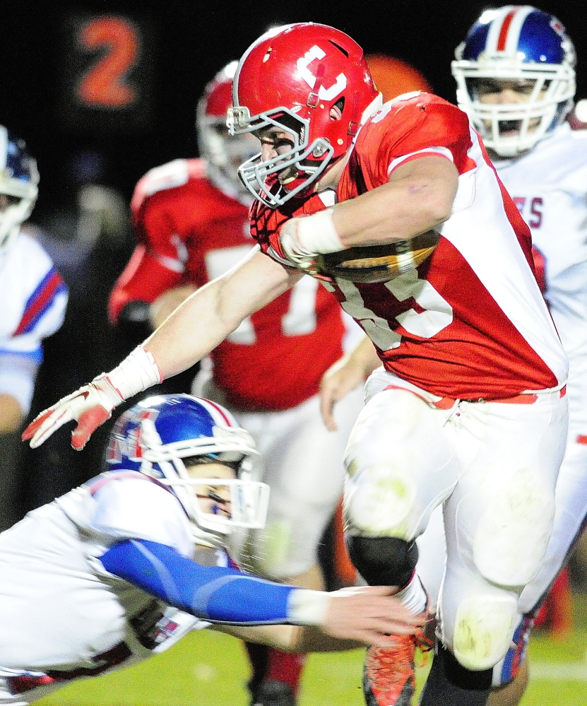 Cony running back Reid Shostak, right, avoids a diving tackle by Messalonskee defensive back Jake Dexter during a game on Nov. 8, 2013, at Alumni Field in Augusta. Cony coach will be watching the 7 on 7 League to see where players are at in their training.