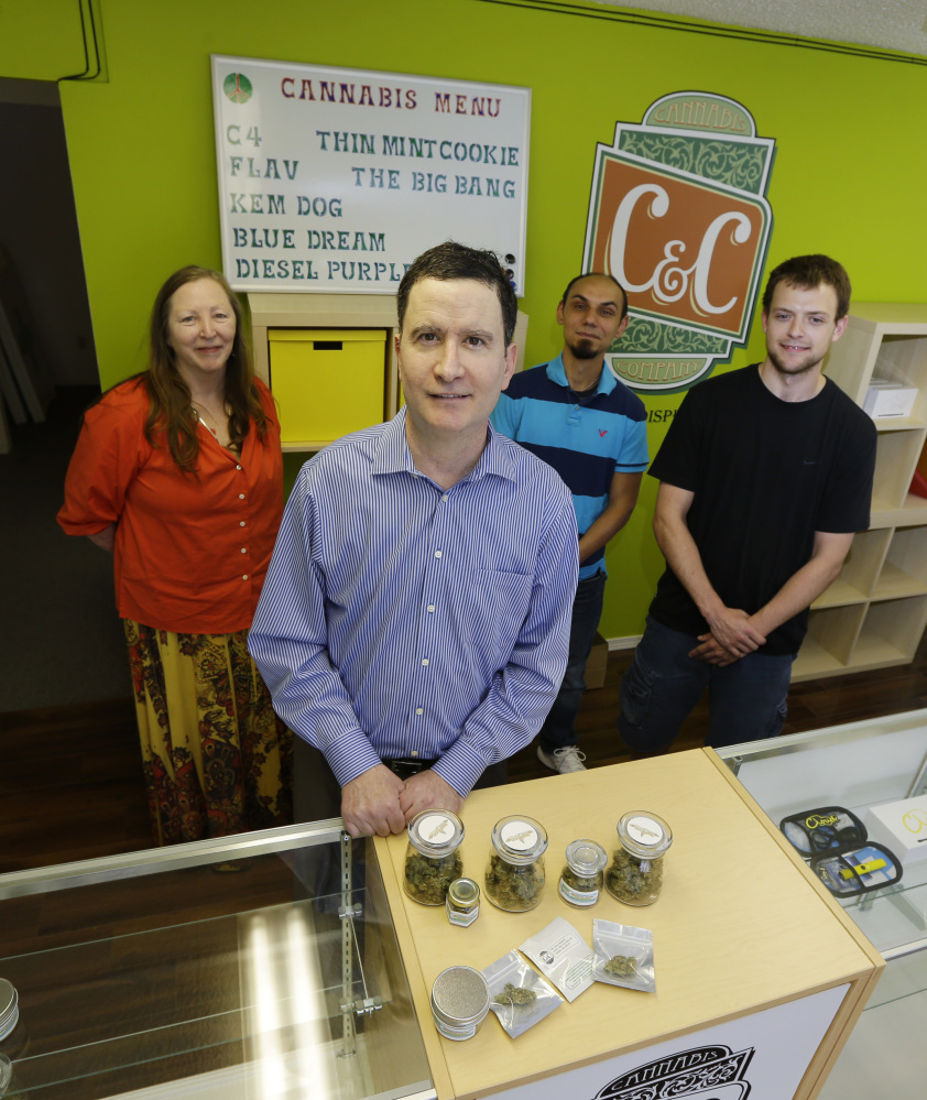 Pete O’Neil, second from left, stands in his soon-to-be-open medical marijuana dispensary in Seattle with three of his employees in the background.