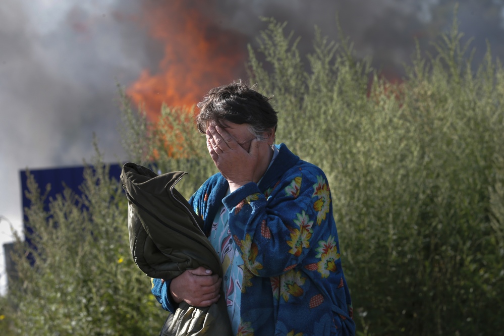 A woman cries near her burning house after shelling in the city of Slovyansk, Donetsk Region, eastern Ukraine, on Monday.