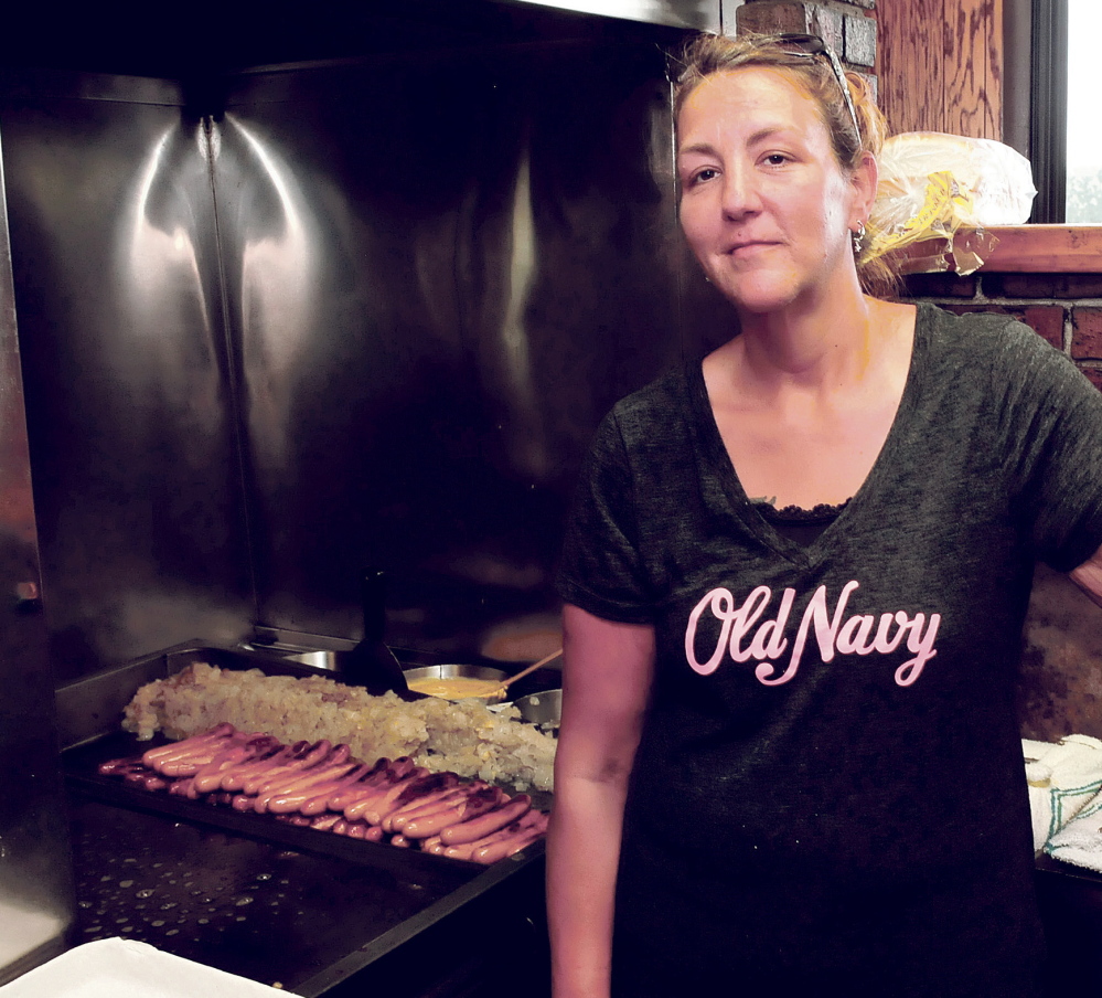 Zena McFadden takes a break from grilling hot dogs and hamburgers during the lunch rush at Bolley’s Famous Franks restaurant in Waterville on Monday. Bolley’s in Waterville is closing Thursday after being in business since 1962.