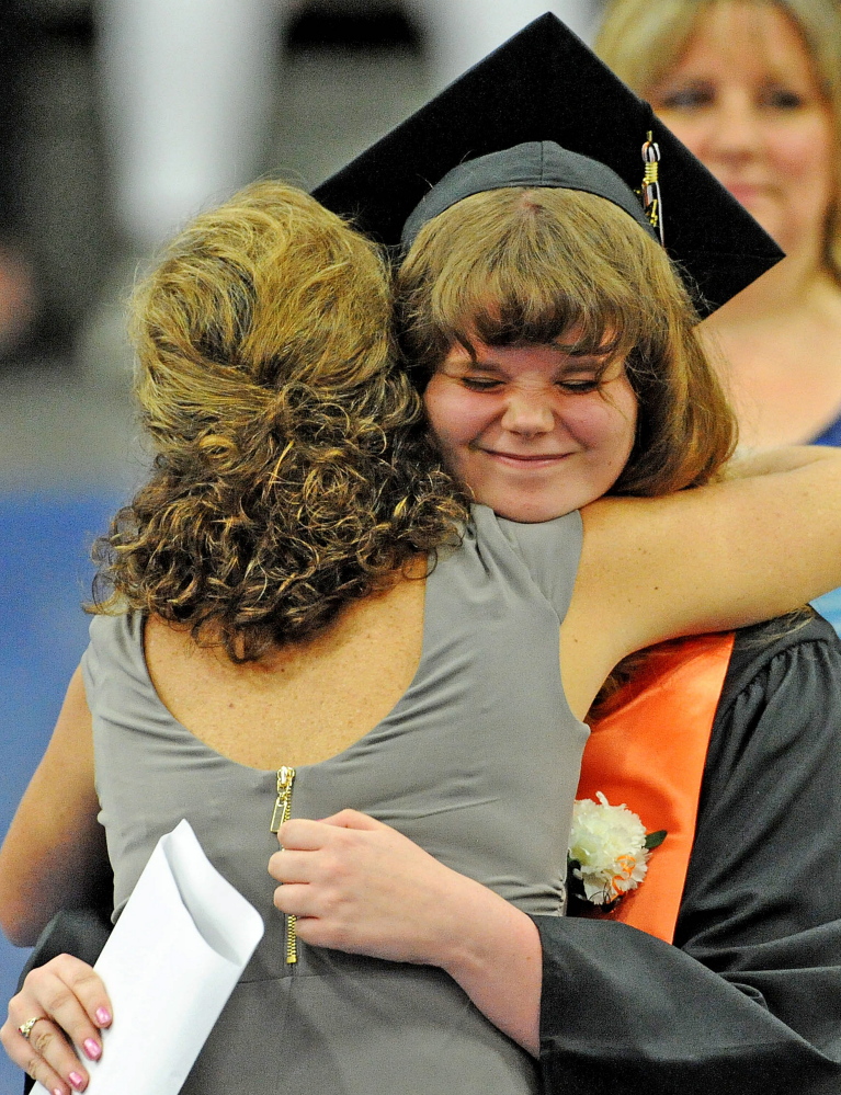 Staff photo by Michael G. Seamans 
 Jessica Carver gets a hug after receiving her diploma during Winslow High School's commencement ceremonies at the Alfond Athletic Center at Colby College in Waterville on Wendesday, June 3, 2014.