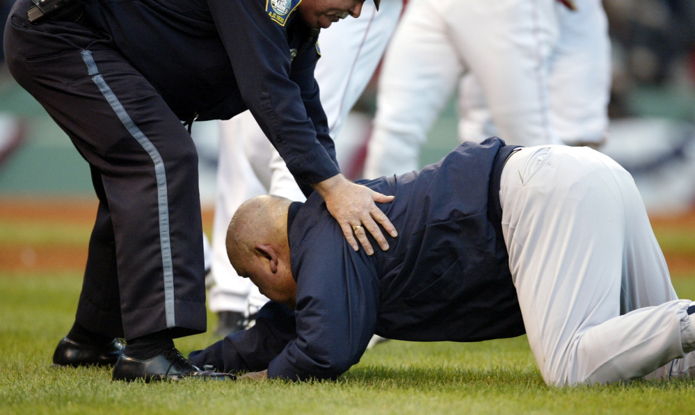 New York Yankees bench coach Don Zimmer lies  on the ground after Boston Red Sox pitcher Pedro Martinez pushed him away in the fourth inning of  Game 3 of the American League Championship Series in Boston, Saturday, Oct. 11, 2003. (AP Photo/Winslow Townson)