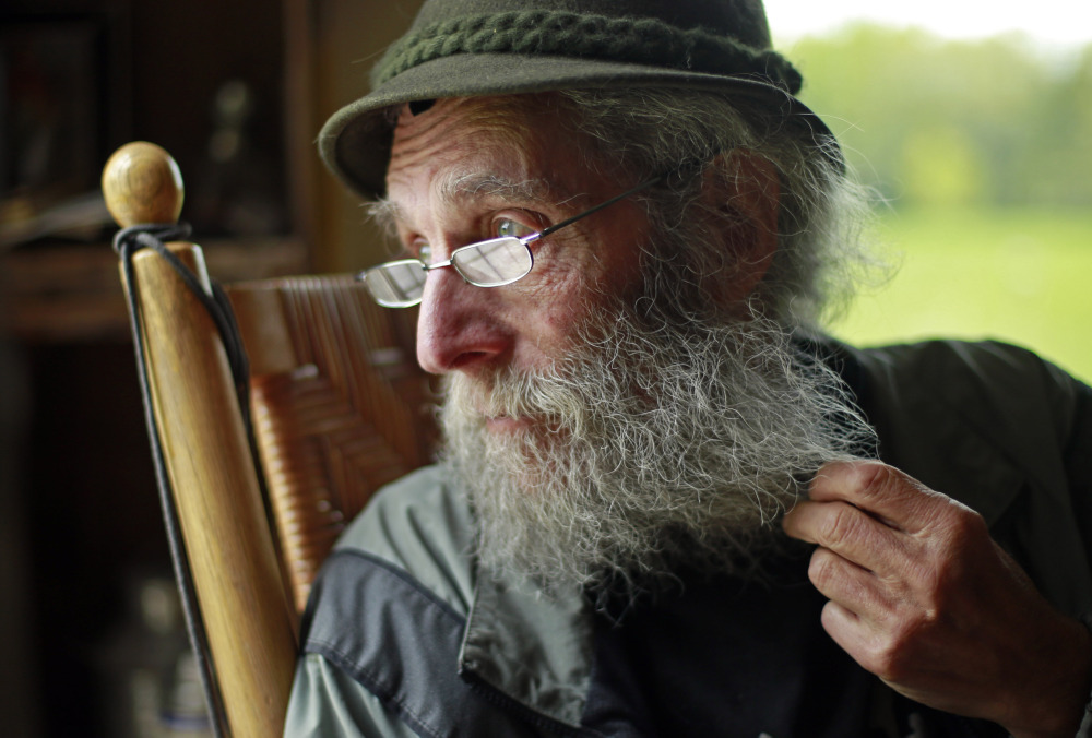 The Associated Press/Robert F. Bukaty Burt Shavitz pauses during an interview in May to watch a litter of fox kits play near his camp in Parkman. The reclusive beekeeper whose simple life became complicated by his status as a corporate icon is now the subject of a documentary, “Burt’s Buzz,” which opens Friday.