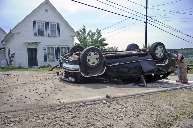 A firefighter contains fluids Tuesday from an SUV that rolled over and injured the driver.  Police say a single occupant of the vehicle was transported by helicopter to a trauma center after the accident occurred on Route 24 just after 11 a.m.