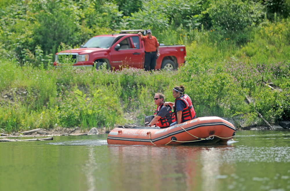 Firefighters from Waterville Fire Department search the area around a dam on the Messalonskee Stream for 82-year-old Wesley Johnston, who went missing Tuesday morning but was found later that evening.