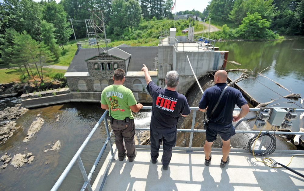 Waterville Fire Department firefighters search the area around a dam on the Messalonskee Stream on West River Road in Waterville Tuesday for Wesley Johnston, 82.