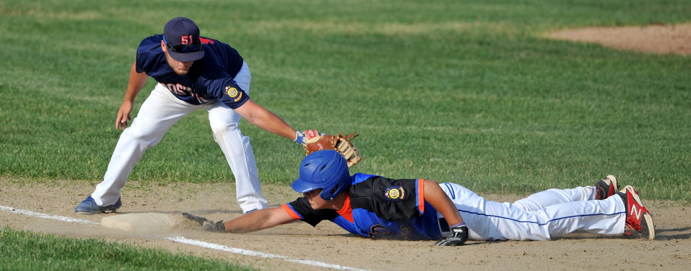 RTD of Madison’s Kam Nelson, 12, dives back to first base before Post 51’s Zach  Mathieu, 9, can apply the tag at first base at Colby College Tuesday. RTD defeated Post 51 5-2.