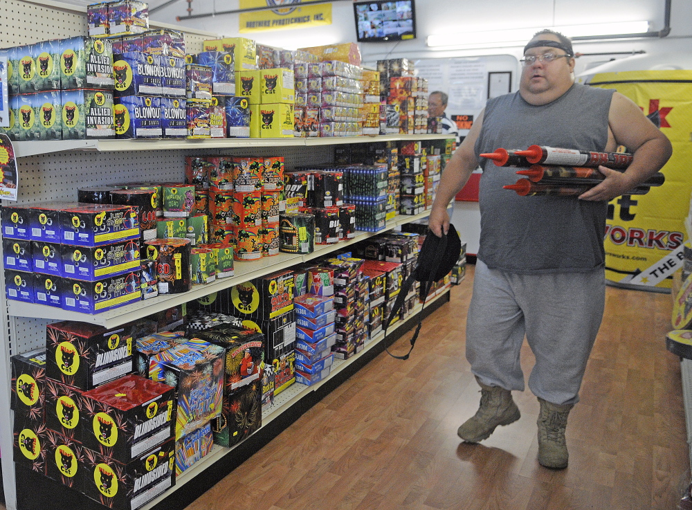 John Bergen of Somerville carries rockets Tuesday from the  Pyro City Retail Store in Manchester. Bergen, a professional explosives engineer, said safety is paramount. “It’s up to the individual to keep it safe so we all can enjoy the tradition,” Bergen stated.