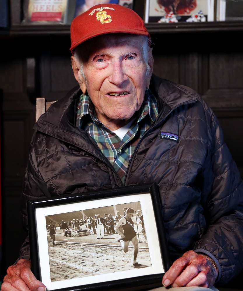 This Jan. 21, 2014 photo, Louis Zamperini displays one of his photographs as a student and sprinter, at his Los Angeles home.