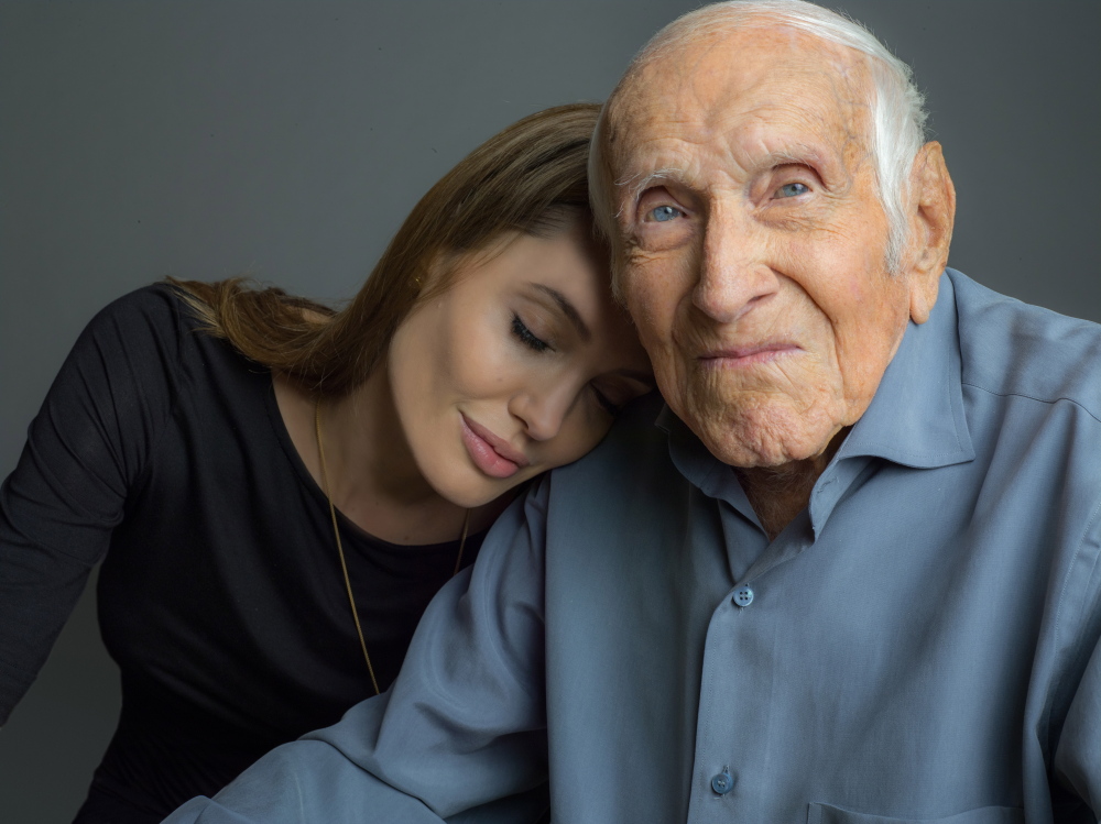 This undated photo provided by Universal Pictures, Angelina Jolie is photographed with Louis Zamperini.  Jolie is directing the Universal movie, “Unbroken,” about the life of Zamperini.