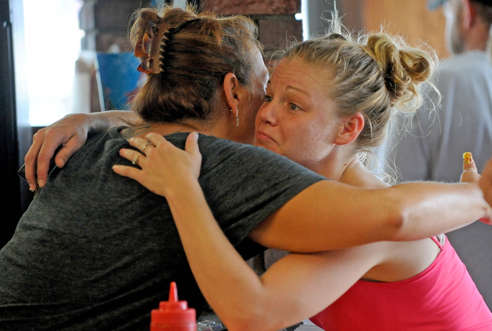 Bolley’s Famous Franks manager Zena McFadden, left, gets a hug Thursday from loyal customer Lindsey Doyle at Bolley’s on College Avenue in Waterville. The landmark lunch destination served its last hot dog Thursday, ending a 52-year run.