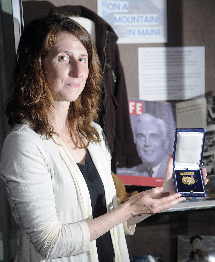 Curator Kate McBrien, at the Maine State Museum in Augusta, holds a medal of valor that Donn Fendler received from President Franklin Roosevelt in 1939. This year is the 75th anniversary of Fendler surviving on Mount Katahdin, an ordeal later chronicled in the book “Lost on a Mountain in Maine.” The museum is exhibiting items from Fendler’s saga.