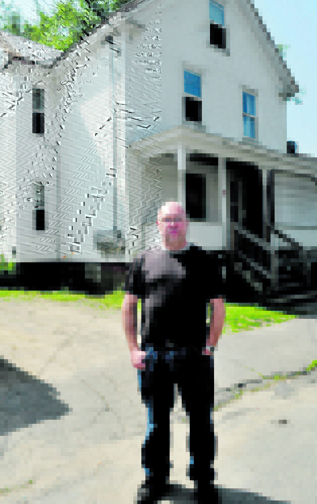 Former Oakland police officer Jim Hamilton stands outside the Summer Street apartment building in Waterville where he discovered the body of his grandmother Evelyn Pomerleau in 1989.