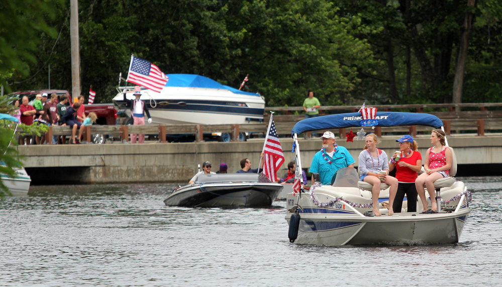 Boaters make their way up Mill Stream on Saturday during the annual boat parade to celebrate Independence Day in Belgrade Lakes village. The event was postponed a day.