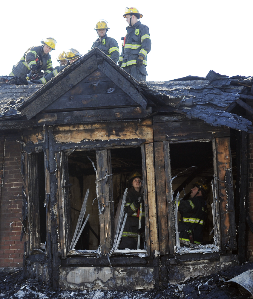 Philadelphia firefighters work on  burned row homes on Saturday in Philadelphia.