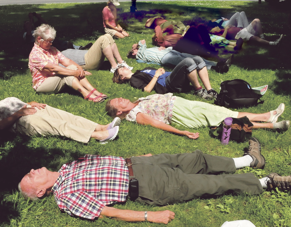 Nearly forty people took part in a memorial at the Universalist Unitarian church in Waterville on Sunday, July 7, 2014, for the 47 victims of the Lac Megantic train tragedy. Participants, including Richard Dillenbeck, front, were asked to lie down in remembrance of the victims who perished in the oil train inferno.