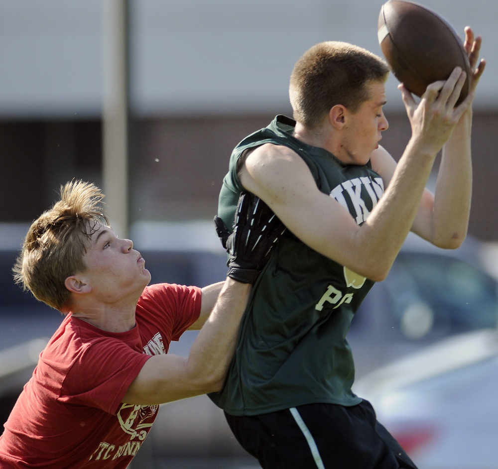 TURNER, ME - JUNE 6: Cony High School's Joel Bennett tags a Oxford Hills High School receiver Sunday July 6, 2014 the annual 7x7 football tournament in Turner. (Photo by Andy Molloy/Staff Photographer)