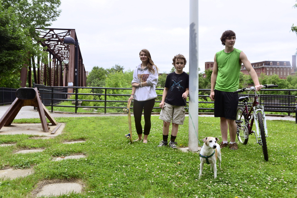 Tessa Kunz (from left), Garret Blackerby, Laughing Sprucebarns and their dog Bean near the Riverwalk Bridge on Thursday, June 26, 2014. Kunz lives in Auburn and Blackerby and Sprucebarns both live in Lewiston. The kids are in favor of merging the cities, and they hope it would lead to better parks and safer neighborhoods in Lewiston.