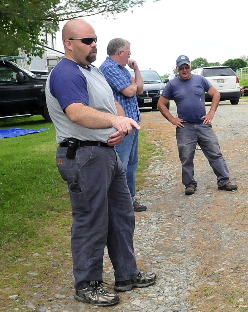 Anson Fire Chief Jeremy Manzer, left, surveys the home of Martha Walker Monday. Fire caused extensive damage on Sunday. Behind Manzer is Stu Jacobs, center, an investigator with the state fire marshal’s office, and Alan Walker, the brother of the homeowner who led her to safety.