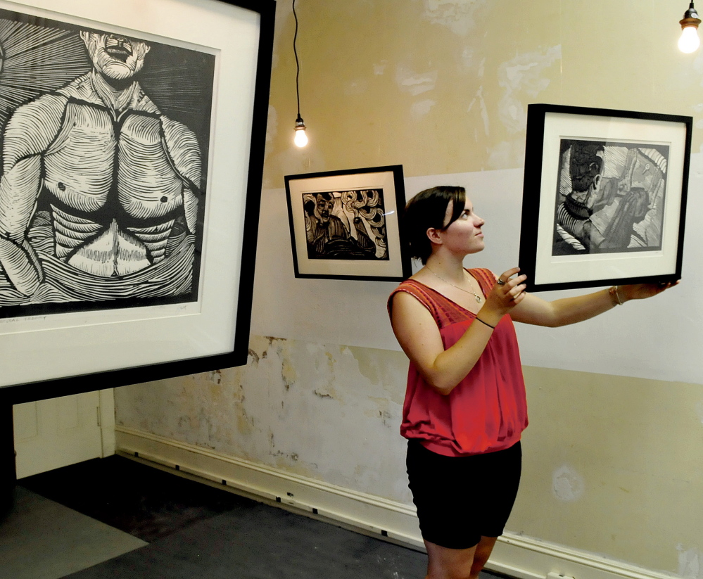 Rachel McDonald, program manager at Common Street Arts in Waterville Monday, hangs artwork that will be part of the Waterville Arts Festival event that is running in conjunction with the Maine International Film Festival this Saturday.