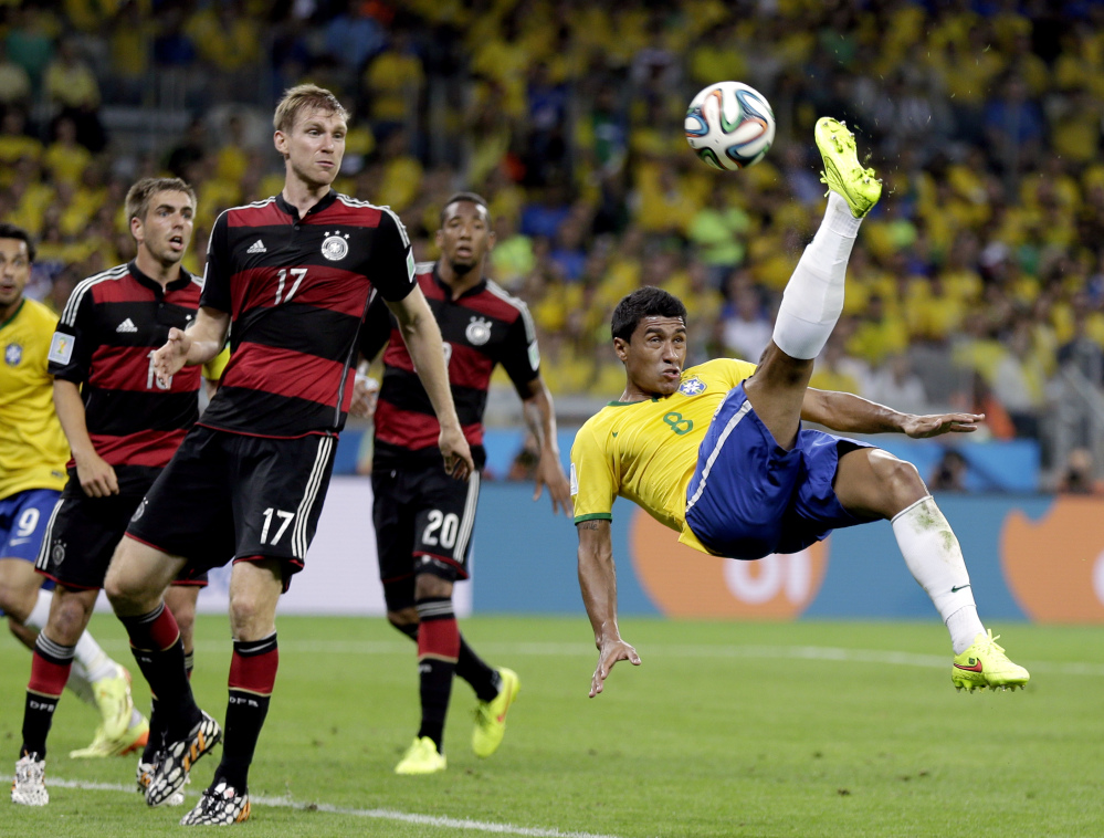 Brazil’s Paulinho (8) kicks the ball in front of Germany’s defenders during the World Cup semifinal Tuesday in Belo Horizonte, Brazil.