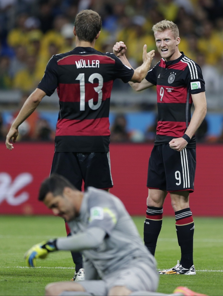 Germany’s Andre Schuerrle, right, celebrates with Thomas Mueller after scoring his side’s sixth goal during the World Cup semifinal soccer match between Brazil and Germany at the Mineirao Stadium in Belo Horizonte, Brazil, Tuesday.
