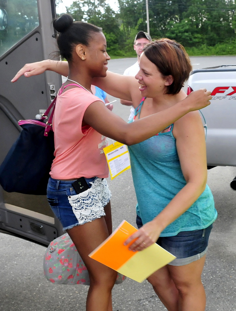 Stepping off a bus after traveling from New York is Shania Payne, left, being greeted by Fresh Air organization family host member Brandy Jewell in Waterville on Monday.