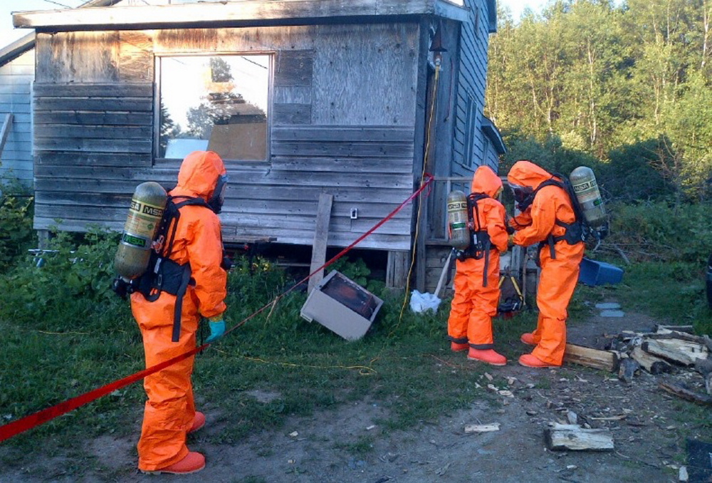 A Maine Drug Enforcement Agency team wears protective gear to dismantle a suspected methamphetamine lab in the Aroostook County town of Merrill on Wednesday.