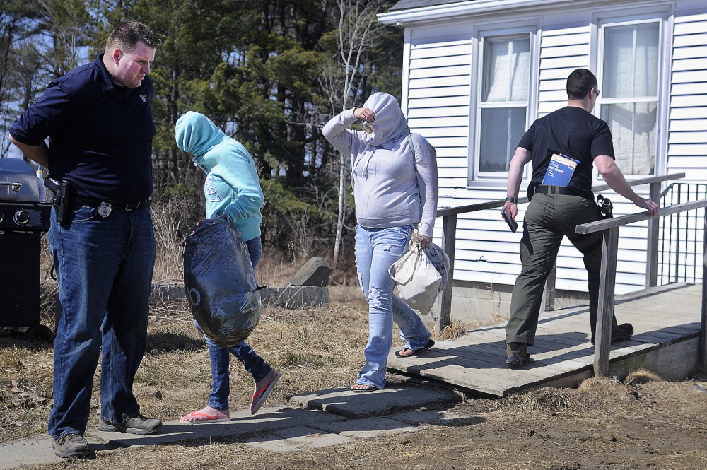 Women leave the residence Fred Horne Sr. in Sidney in April after a raid by several state, local and federal law enforcement agencies.