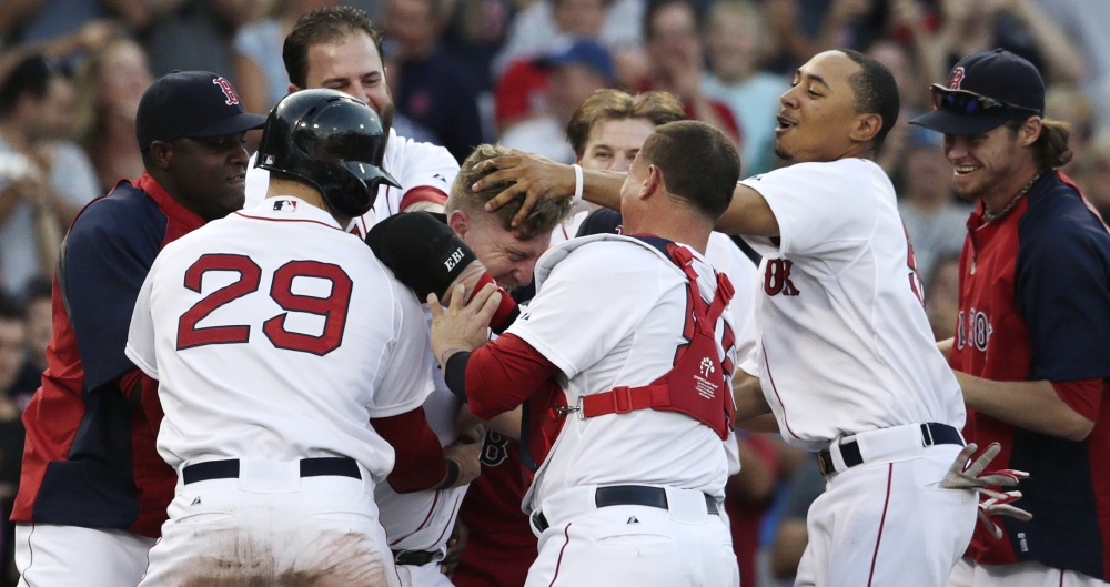 Boston Red Sox pinch hitter Mike Carp, center is congratulated by teammates after his walk-off RBI single, breaking a 3-3 tie, Thursday against the Chicago White Sox at Fenway Park in Boston. The Red Sox defeated the White Sox 4-3 in 10 innings.