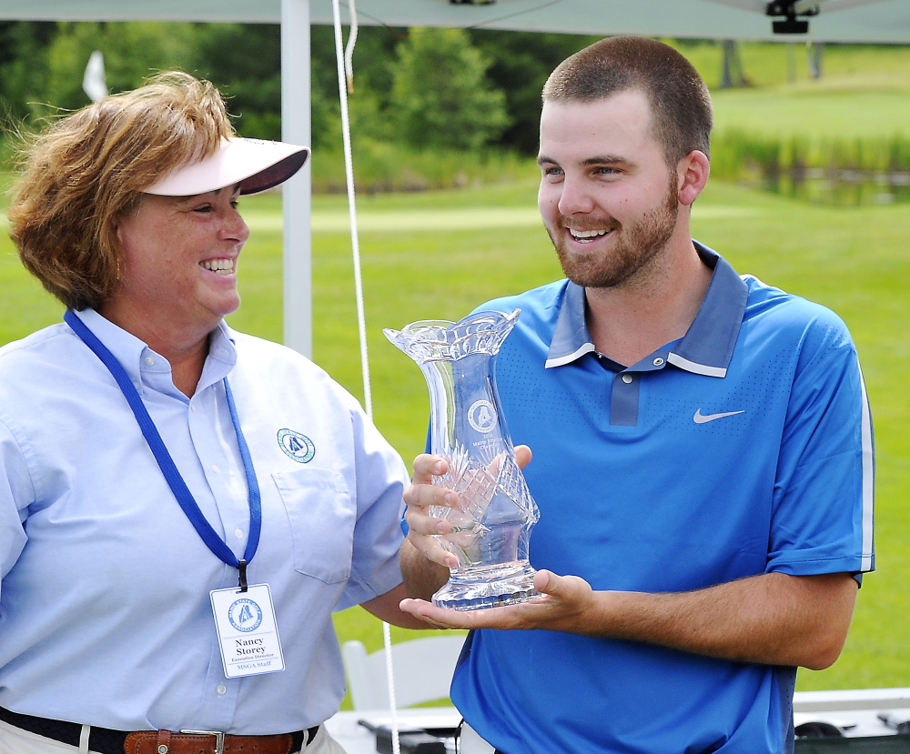 Maine State Golf Association Director Nancy Storey, left, hands the trophy to Andrew Slattery after the final round of the Maine Amateur Championship on Thursday at the Woodlands in Falmouth. Slattery won by one stroke.