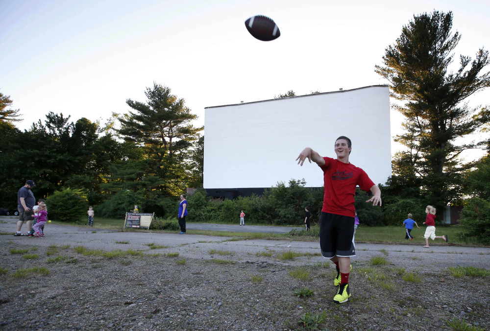 Shawn Smart, on vacation from Athol, Mass., plays catch with a football while waiting for the sun to set at the Saco Drive-In in Saco.