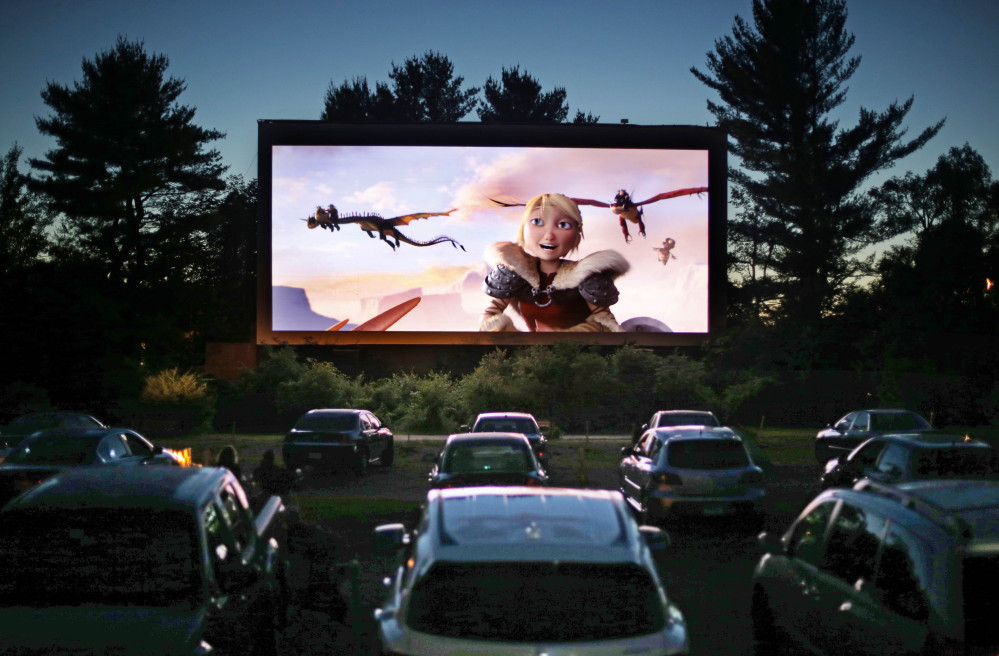 Movie-goers watch How to Train Your Dragon 2, the first movie of a double feature at the Saco Drive-In in Saco. Drive-in movie theater operators say more than 200 of the remaining 348 drive-ins in the country have made the costly switch from film to digital.