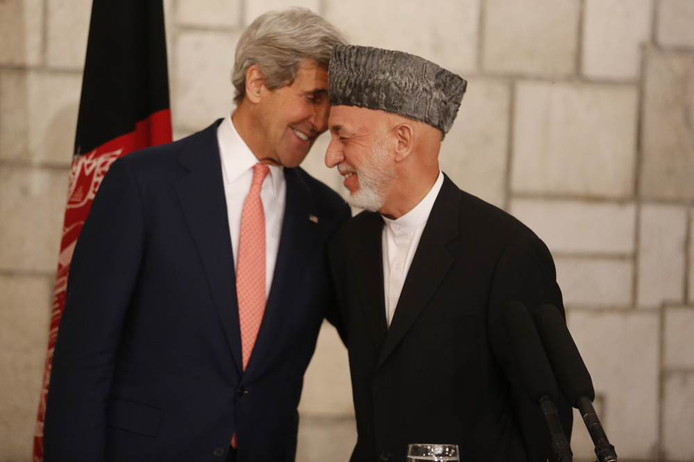 Afghanistan’s president Hamid Karzai, right, laughs as he holds a news conference with  U.S. Secretary of State John Kerry and United Nations Representative Jan Kubis at the Presidential Palace in Kabul, Saturday.
