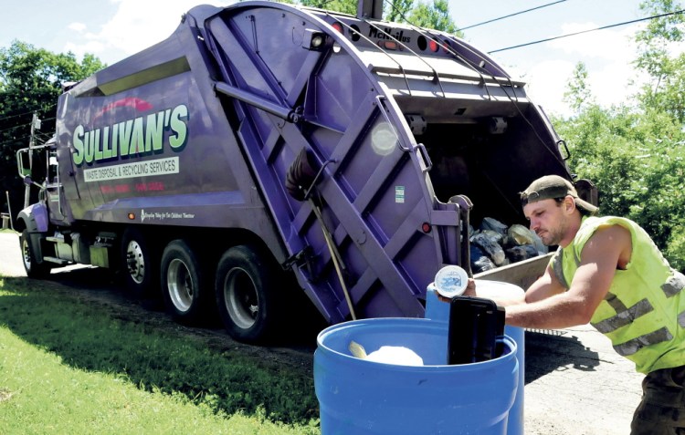 Trucks from Sullivan’s Waste Disposal and Recycling soon will become a familiar sight on Waterville streets. Jerry Allen, an employee of the company, empties recyclable materials into a company truck. The Thorndike company has the contract to pickup recycling in the city.